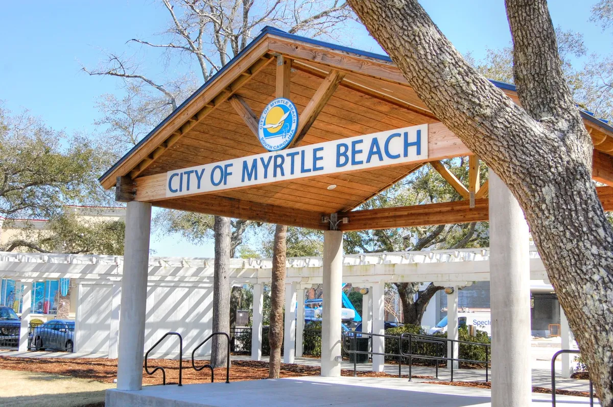 This exterior shot presents the City of Myrtle Beach sign and a wooden pavilion surrounded by trees. It signals the community’s welcoming atmosphere and hints at nearby parks or communal spaces where dogs are welcome.