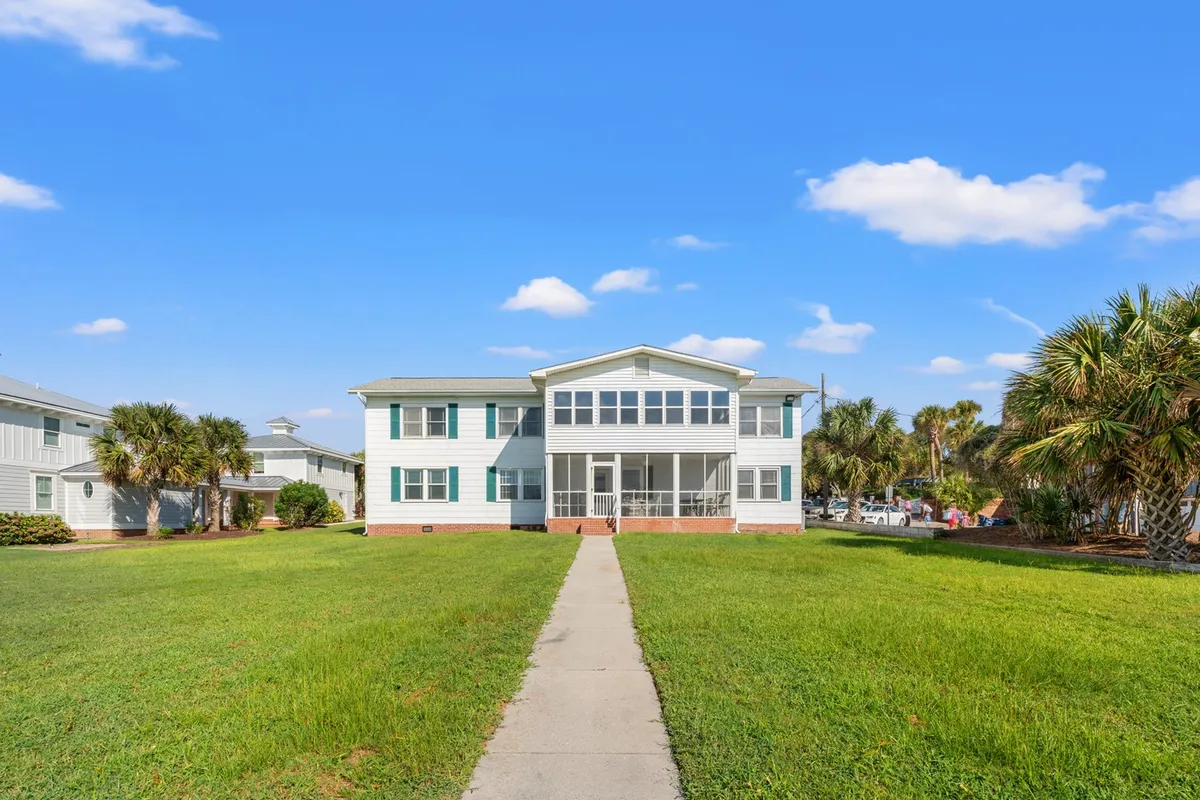 The image shows a welcoming front porch with large windows and a manicured lawn, ideal for outdoor relaxation and play. The open lawn provides a safe and inviting space where dogs and their owners can enjoy fresh air, while the porch suggests comfortable mornings or evenings spent together.